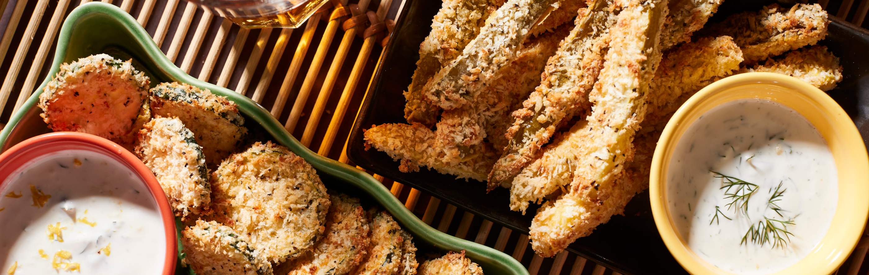 Assorted air-fried vegetables on and dipping sauce on tray.